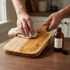 Oiling an olive wood serving board in the kitchen