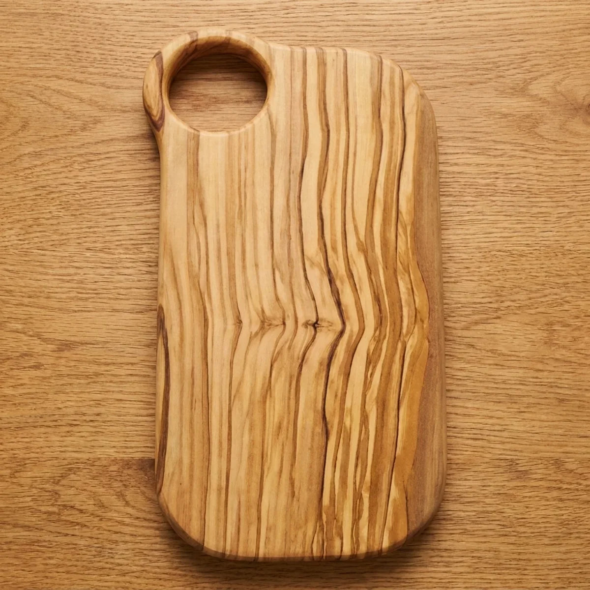 The Alba Olive Wood Board with Grip Hole seen from above, the full grain readable