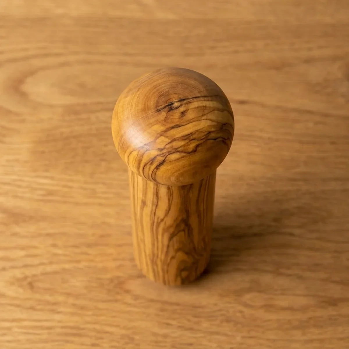 The Alba Olive Wood Pepper Mill seen from above, the full grain readable