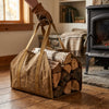 Waxed canvas log carrier full of split logs set down next to the wood stove