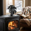 Farmhouse living room with the stove fan turning on the wood stove and an armchair across the room