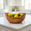 The bowl on a kitchen island filled with lemons and limes
