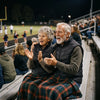 Couple wearing Calvane heated vests at an evening football game