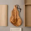 The Alba Olive Wood Board with Leather Loop with its kraft wrapping and plain shipping box