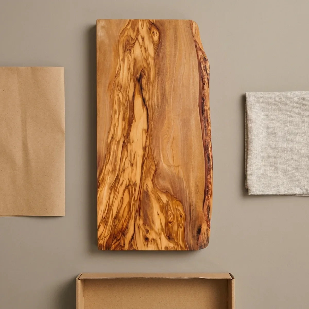 The Alba Live-Edge Olive Wood Slab with its kraft wrapping and plain shipping box