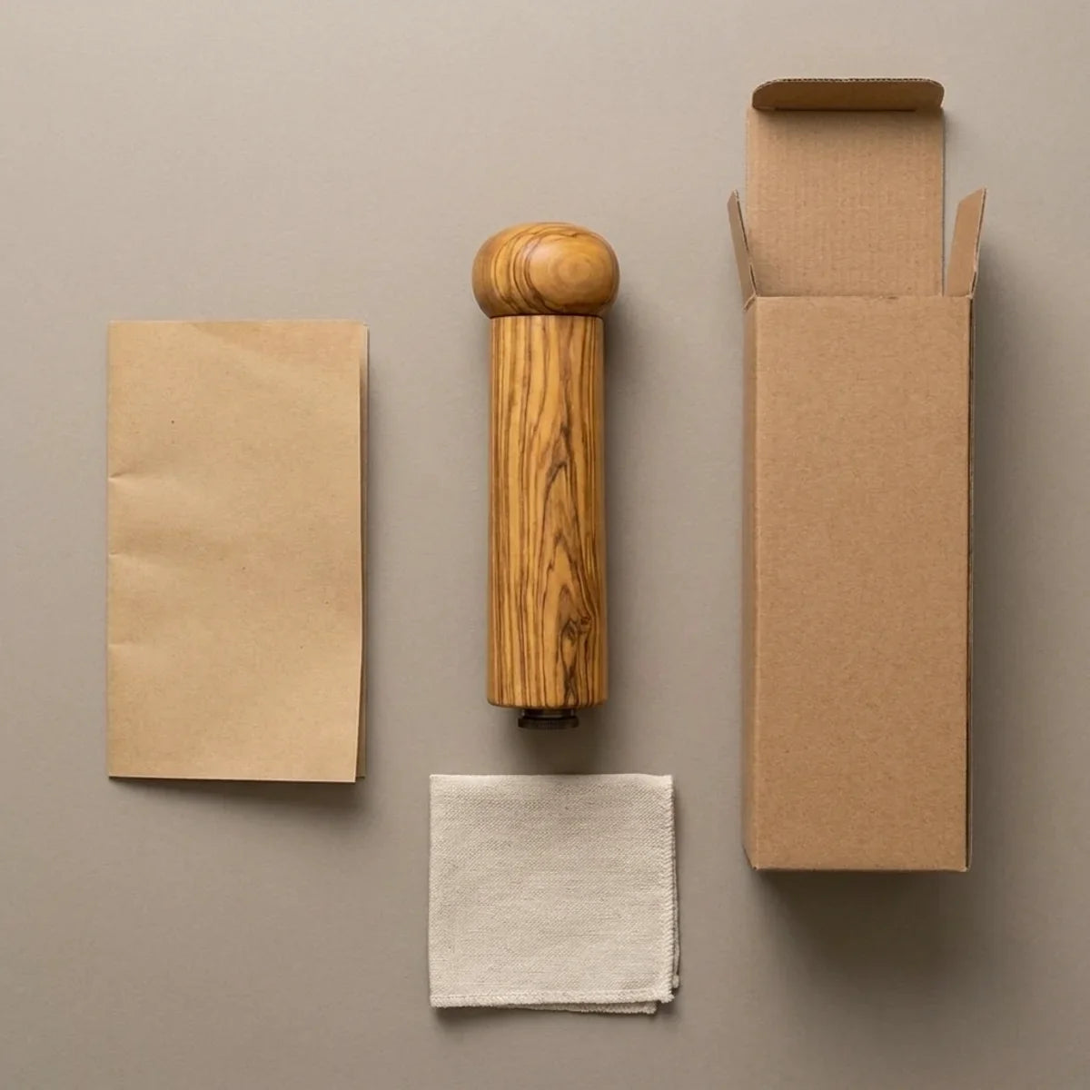The Alba Olive Wood Pepper Mill with its kraft wrapping and plain shipping box