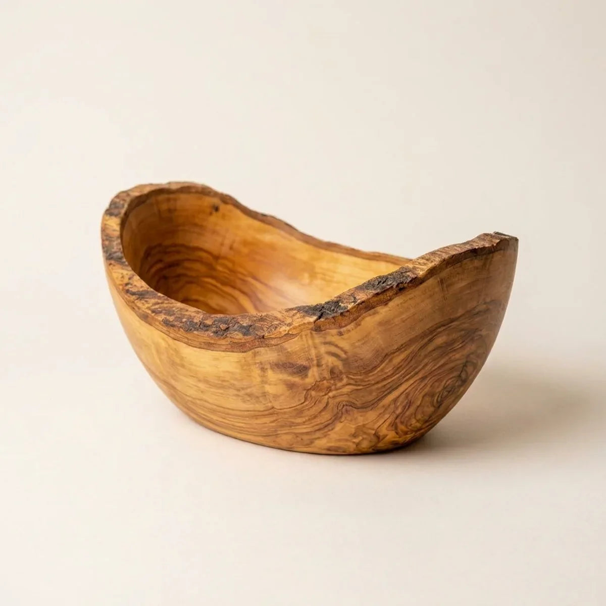 The Ostuni olive wood serving bowl alone on a plain background